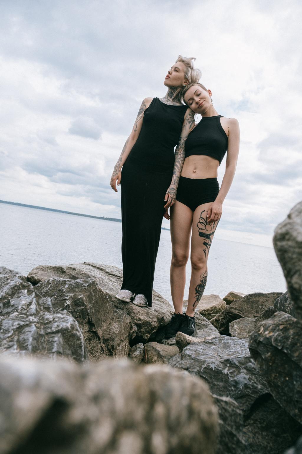 alternative looking couple with tattoos showing tender love and affection in front of natural landscape